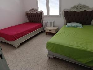 two beds sitting next to each other in a bedroom at HERGLA Sousse Zone Touristique in Harqalah