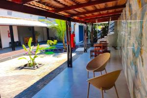 a patio with chairs and tables in a building at VELINN Pousada Entre Praias Itaguá in Ubatuba