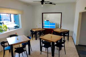 a room with tables and chairs and a mirror at VELINN Pousada Entre Praias Itaguá in Ubatuba