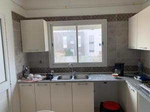 a kitchen with a sink and a window at HERGLA Sousse Zone Touristique in Harqalah
