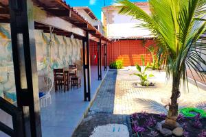 a patio with a palm tree and a restaurant at VELINN Pousada Entre Praias Itaguá in Ubatuba