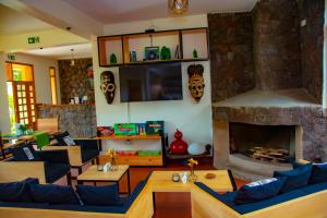 a living room with couches and a fireplace at Coffee Pot Hotel in Kisoro