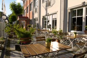 an outdoor patio with tables and chairs and plants at Hotel Villa Subklew in Ostseebad Sellin
