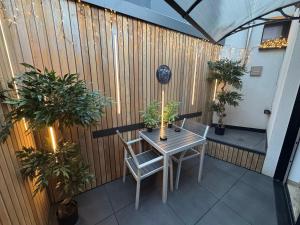 a table and chairs on a balcony with plants at Studio détente, sdb privative, billard, air soccer, clim in Verviers