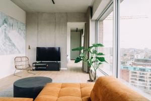 a living room with a couch and a tv at De Hoorn in Leuven