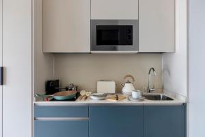 a kitchen with a sink and a microwave at Calido Alcobendas in Alcobendas