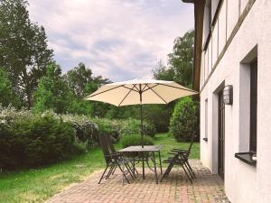 a table and chairs with an umbrella on a patio at Windrose 08 in Ahrenshoop
