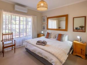 a bedroom with a bed with a mirror and a chair at The Gentleman in Montagu