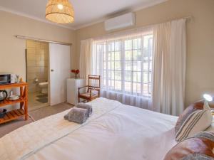 a bedroom with a large white bed and a window at The Gentleman in Montagu