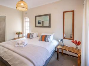 a bedroom with a large white bed and a mirror at The Gentleman in Montagu +4 photos