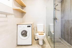 a bathroom with a washing machine and a toilet at Casa Bodega Coco in Puerto del Carmen +17 photos