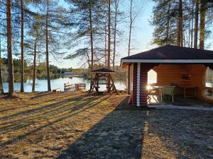 a log cabin with a table and a gazebo at Venetsianranta in Saarijärvi