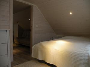 a bedroom with a white bed in a attic at Villa Korpilo in Somero