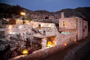 a stone building with a balcony and a building with lights at Private Stone villa-Pool and Maountain view in Karés