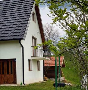 a white house with a balcony on the side of it at Peaceful Cottage in Bijelo Polje