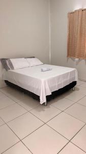 a bed sitting on a tiled floor in a room at Casa jatobá in Petrolina
