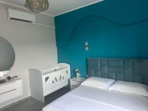 a bedroom with a blue wall and a bed at Erdi's Home in Berat
