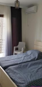 a bedroom with a bed and a chair and a window at SHEKVETILI s in Kokotauri