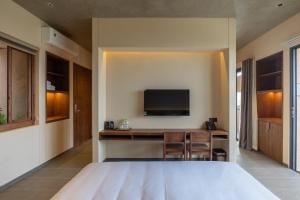 a hotel room with a desk and a tv at The Charm Hotel Phan Thiet in Ấp Bình Hưng