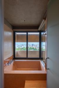 a large bath tub in a room with a window at The Charm Hotel Phan Thiet in Ấp Bình Hưng