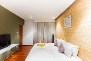 a bedroom with a white bed and a television at DARZA LUXURY RESORTs in Coimbatore