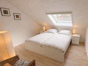 a bedroom with a bed and a window in a attic at Sand & Siel Dangast in Dangast