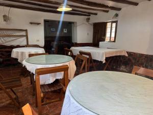 a room with two tables and chairs with tablesablish at ollanta lodge in Ollantaytambo