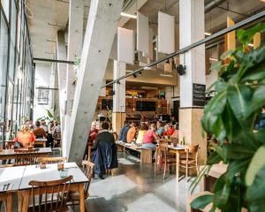 a group of people sitting at tables in a restaurant at De Hoorn in Leuven
