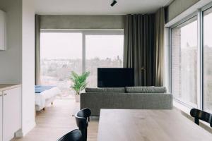 a living room with a couch and a large window at De Hoorn in Leuven +31 photos