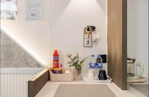 a kitchen with a shelf with bottles and a sink at Coolplay house in Bangkok