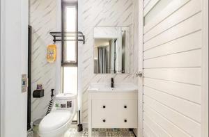 a bathroom with a sink and a toilet and a mirror at Coolplay house in Bangkok