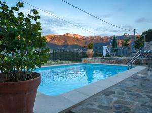 a blue swimming pool with mountains in the background at Private Stone villa-Pool and Maountain view in Karés