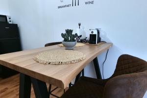 a wooden table with two chairs and a plant on it at La Casa Della Zia Scicli in Scicli