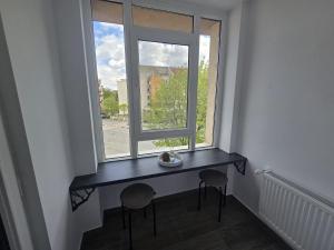 ein Tisch in einem Zimmer mit Fenster in der Unterkunft BlueBee Hive in Orăştie