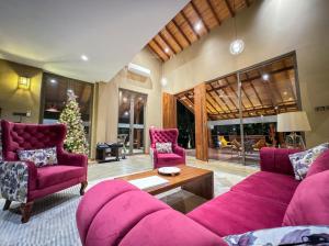a living room with a purple couch and a christmas tree at Allure Yala Luxury Suites by Allure Leisure in Yala