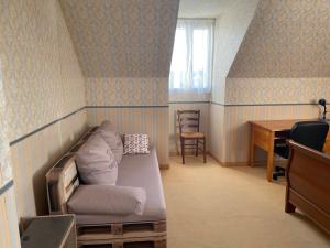 a room with a couch and a table and a desk at Oasis de Bonheur à Amaryllis in La Guierche