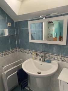 a bathroom with a sink and a mirror at Oasis de Bonheur à Amaryllis in La Guierche