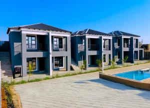 a row of houses with a swimming pool at Overflow Accommodation Lodge in Louis Trichardt