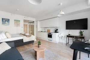 a living room with a bed and a flat screen tv at Luminary - Tampere City Center Apartments by Come in! in Tampere