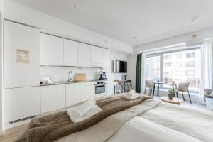 a bedroom with white cabinets and a large bed at Luminary - Tampere City Center Apartments by Come in! in Tampere