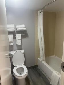 a bathroom with a toilet and a shower and a tub at Econo Lodge Naval Station Norfolk in Norfolk +13 photos