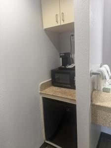a small kitchen with a microwave and a counter at Econo Lodge Naval Station Norfolk in Norfolk