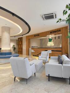 a lobby with white couches and chairs in a building at Resort Sur Beach Holiday in Sur