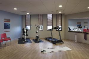 a gym with treadmills and exercise equipment in a room at DOMITYS - Le Ruban d'Azur in Sète