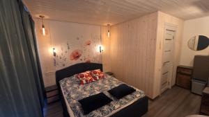 a small bedroom with a bed with red pillows on it at Central Riverside Apartments in Jēkabpils
