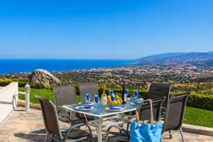 a table and chairs with a view of the ocean at Villa Panorama Tria in Drousha