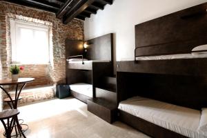Cette chambre comprend 2 lits superposés et une table. dans l'établissement New Generation Hostel Rome Center, à Rome