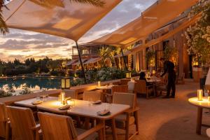 a restaurant with tables and a person standing in front of a pool at Mandarin Oriental, Marrakech in Marrakesh