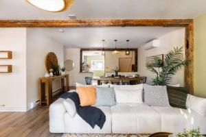 ein Wohnzimmer mit einem weißen Sofa und einem Tisch in der Unterkunft The River Nest in Bracebridge