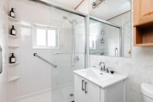 ein weißes Badezimmer mit Waschbecken und Dusche in der Unterkunft The River Nest in Bracebridge + 59 Fotos